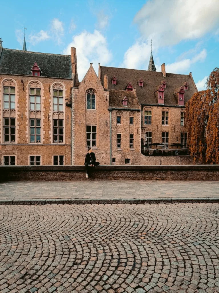 a person sitting on a bench in front of a building